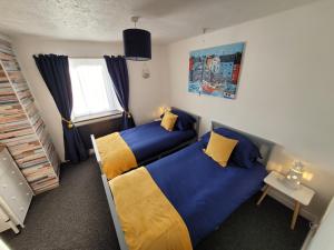 ein Schlafzimmer mit zwei Betten und einem Fenster in der Unterkunft Charming pet friendly 2 bedroom cottage, close to Narberth & local beaches, friendly animals on our smallholding in Pembrokeshire