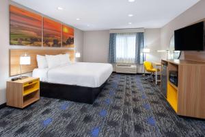 a hotel room with a bed and a flat screen tv at Days Inn by Wyndham Wooster in Wooster