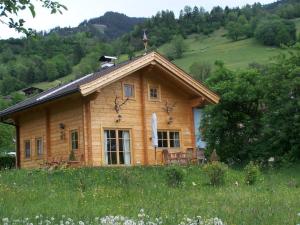 ein Holzhaus auf einem Hügel auf einem Feld in der Unterkunft Knusperhäusl in Uttendorf