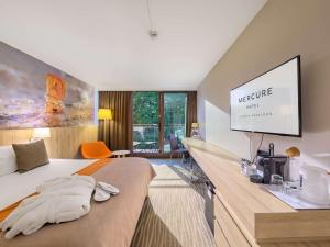 a hotel room with a bed and a projection screen at Mercure Gdańsk Posejdon in Gdańsk
