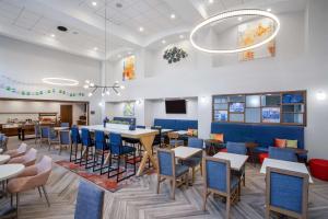 uma sala de jantar com mesas e cadeiras em Hampton Inn & Suites Muncie em Muncie