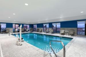 uma piscina num hotel com mesas e cadeiras em Hampton Inn & Suites Muncie em Muncie