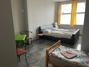 a room with two beds and chairs and a window at Lilla motel in Hegyeshalom