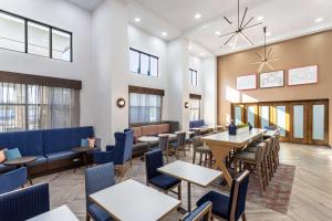 un restaurante con mesas, sillas y ventanas en Hampton Inn & Suites Richmond, en Richmond