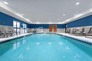 einen großen Pool mit blauen Wänden und Stühlen in der Unterkunft Hampton Inn & Suites Richmond in Richmond