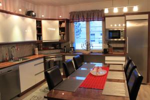 a kitchen with a table and a dining room at Villa Koivikko in Rovaniemi