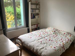 een slaapkamer met een bed en een boekenplank bij Maison village de Créteil in Créteil