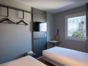 1 dormitorio con cama blanca y ventana en ibis budget Nice Aeroport en Niza