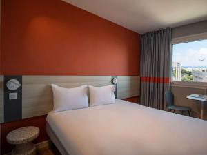 um quarto de hotel com uma cama e uma janela em ibis budget Nice Aeroport em Nice