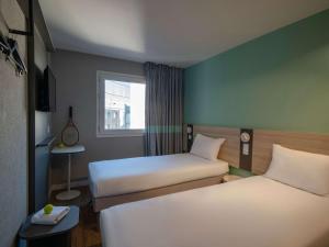 ein kleines Zimmer mit 2 Betten und einem Fenster in der Unterkunft ibis budget Nice Aeroport in Nizza