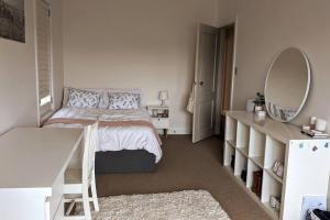 een witte slaapkamer met een bed en een spiegel bij Tranquil Escape at Balmoral Beach in Sydney