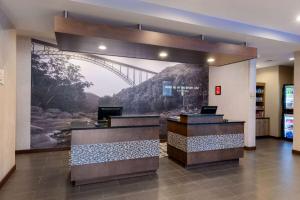 a lobby with a mural of a bridge on the wall at La Quinta by Wyndham Morgantown in Morgantown