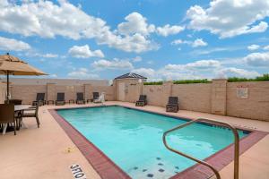 a swimming pool on a patio with a table and chairs at Comfort Inn & Suites, Odessa I-20 in Odessa