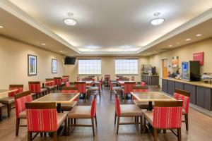 una sala da pranzo con tavoli e sedie rosse di Comfort Inn & Suites a Odessa