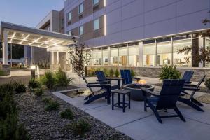 a patio with chairs and a table in front of a building at Microtel Inn & Suites by Wyndham Macedon in Macedon