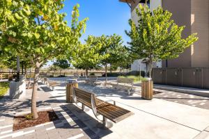a park with benches and trees on a sidewalk at Hampton Inn San Jose Cherry Ave, CA in San Jose