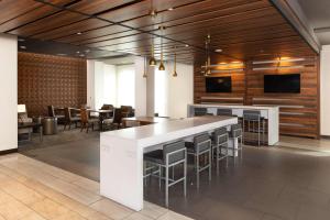 a large kitchen with a bar with chairs and tables at Hampton Inn San Jose Cherry Ave, CA in San Jose