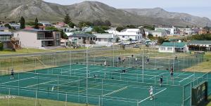 a group of people playing tennis on a tennis court at Kleinmond Panorama Holidays in Kleinmond