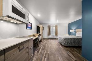 a room with a kitchen and a bedroom with a bed at WoodSpring Suites Dearborn Detroit in Dearborn +50 photos