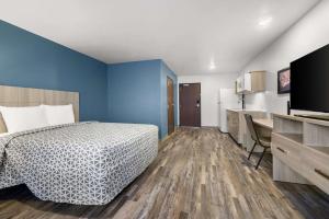 A bed or beds in a room at WoodSpring Suites Dearborn Detroit