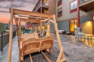 een veranda met stoelen en een schommel op een patio bij Cambria Hotel Lake Placid - Lakeside Resort in Lake Placid