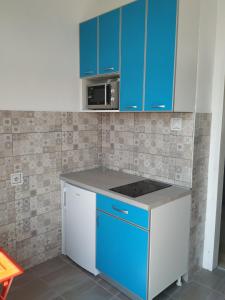 uma cozinha com armários azuis e um micro-ondas em Apartment Modena Novi Sad em Novi Sad