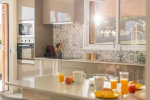 a kitchen with a counter with oranges and glasses of orange juice at Family vacation on Golden Island La Maison Dorée in Porto Santo