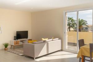 uma sala de estar com um sofá e uma televisão em Family vacation on Golden Island La Maison Dorée em Porto Santo
