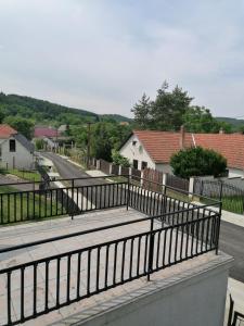 einen Balkon mit einem Zaun und eine Straße mit Häusern in der Unterkunft Erdőszéli Házikó Vendégház in Bükkszék