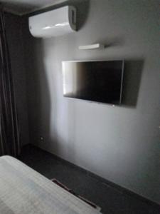 a bedroom with a flat screen tv on the wall at Uniclub House in Cosenza