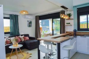eine Küche und ein Wohnzimmer mit einem Sofa und einem Tisch in der Unterkunft Villa Idylle quatre etoiles in Rivière