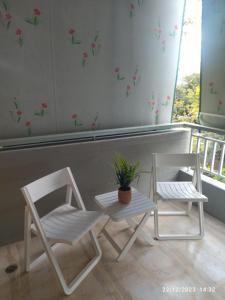 two white chairs and a table and a potted plant at Swan Paradise Glyfada Apartment in Athens +15 photos