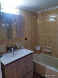 a bathroom with a sink and a tub and a mirror at Swan Paradise Glyfada Apartment in Athens
