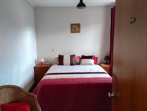 ein Schlafzimmer mit einem Bett mit einer lila Decke in der Unterkunft Sweets Suites in Espinho