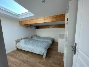 a bedroom with two beds in a room with a skylight at Grand Duplex Argenté 3 chambres à 20min de Paris in Argenteuil