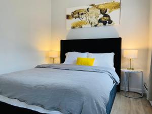 ein Schlafzimmer mit einem Bett mit gelbem Kissen und zwei Lampen in der Unterkunft NYC Oasis in Mott Haven + 16 Fotos