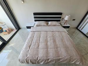 um quarto com uma cama grande e uma cabeceira preta em Konak Tower Seaside mahmutlar em Alanya