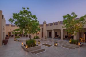 a courtyard of a building with candles and trees at The Chedi Al Bait, Sharjah in Sharjah
