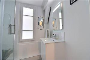 Baño blanco con lavabo y espejo en O'bistrot Troyen - charme secteur piéton Mon Groom, en Troyes
