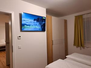 a flat screen tv on the wall of a bedroom at Appartement Heimatliebe in Schladming