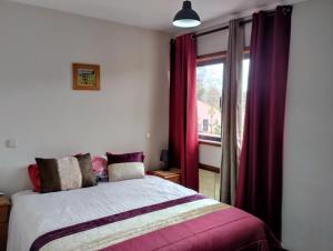 Schlafzimmer mit einem Bett mit roten Vorhängen und einem Fenster in der Unterkunft Sweets Suites in Espinho