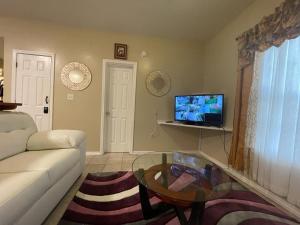 a living room with a couch and a table and a tv at Cozy 3Bdr 2Bth 1st floor Unit in New Orleans