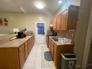 a kitchen with wooden cabinets and a sink and a door at Cozy 3Bdr 2Bth 1st floor Unit in New Orleans