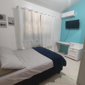 1 dormitorio con 1 cama y TV en Casa de 2 Quartos na Praia da Joaquina, en Florianópolis