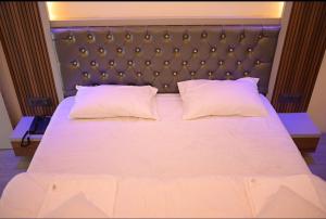 1 cama blanca grande con 2 almohadas en Hotel Kapila Inn Ranjangaon, en Pune