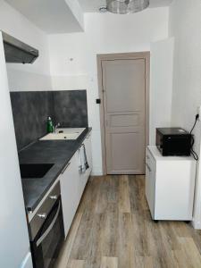 uma cozinha com um lavatório e uma bancada em Appart T3 à Pamiers em Pamiers