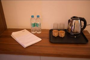 una encimera con 2 botellas de agua y un hervidor de agua en Hotel Kapila Inn Ranjangaon, en Pune