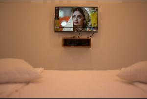 TV en la pared en una habitación con cama en Hotel Kapila Inn Ranjangaon en Pune