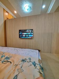 1 dormitorio con 1 cama y TV en la pared en 南田旅宿 en Nan-k'eng