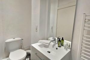 a white bathroom with a toilet and a sink at Le Village - Appart Terrasse Proche gare in Sainte-Savine